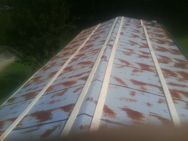 Rusted metal roof panels with new wood purlins before replacement — Storm Damage Roof Repair in South Glens Falls by Roofing Brothers