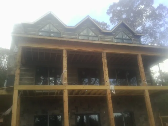 Dormers and porch framing on a large log home under construction — Roof Coating work by our crew in South Glens Falls