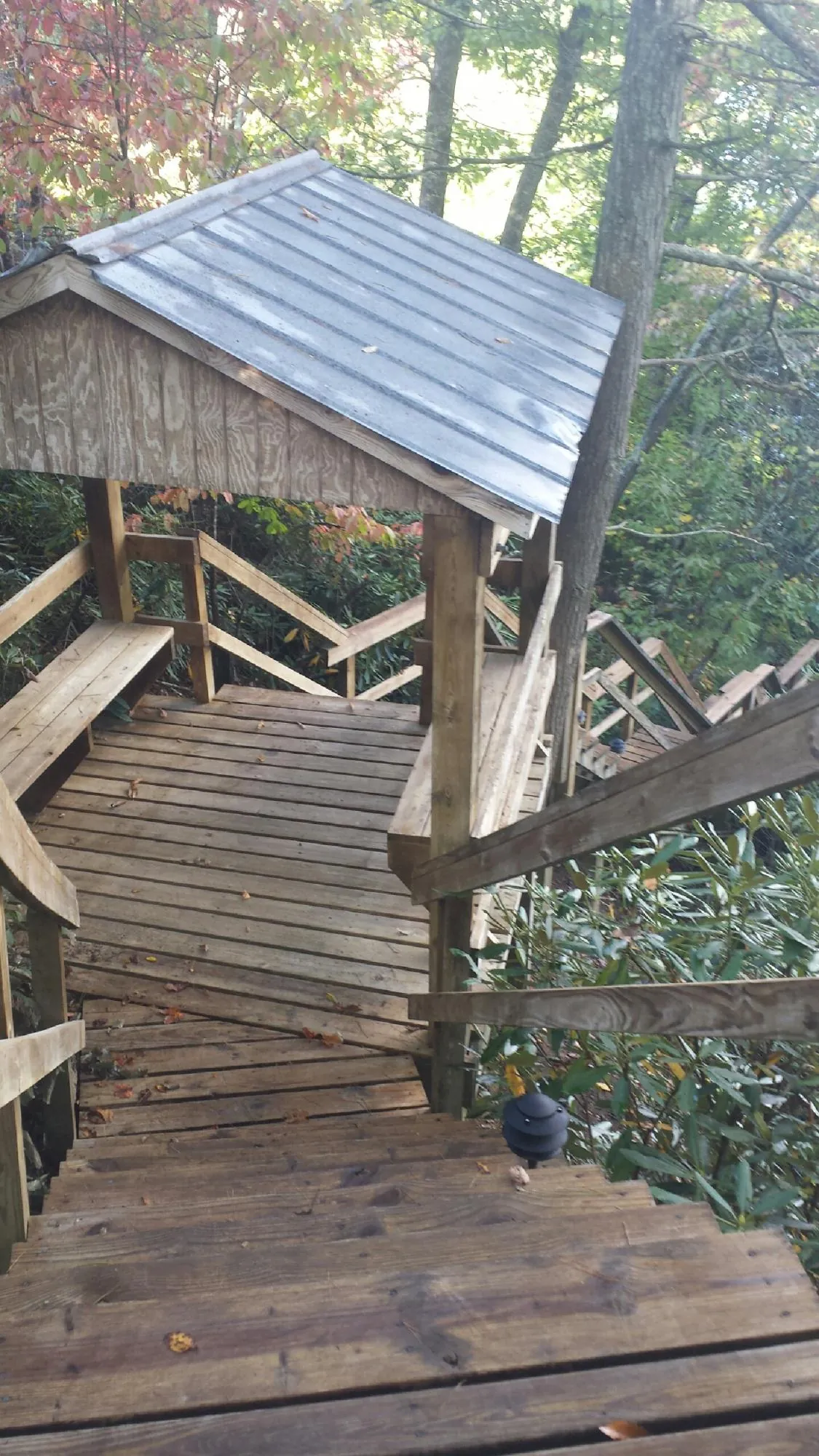 Metal roofed shelter over wooden steps on a wooded walkway — Skylight Repair & Installation work by our crew in South Glens Falls