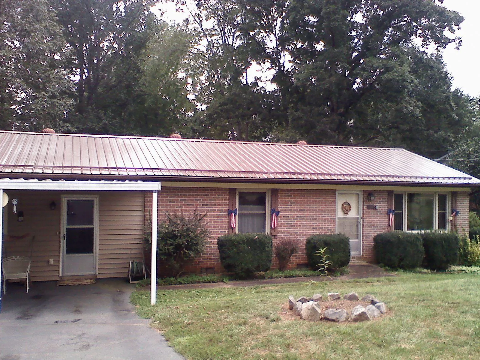 Bronze metal roof and carport on a brick ranch home — Roof Repair work by our crew in South Glens Falls